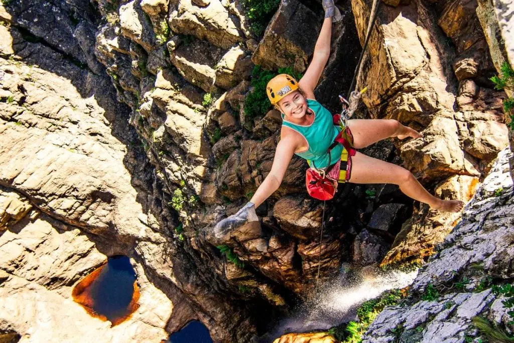 Woman abseiling down a waterfall.