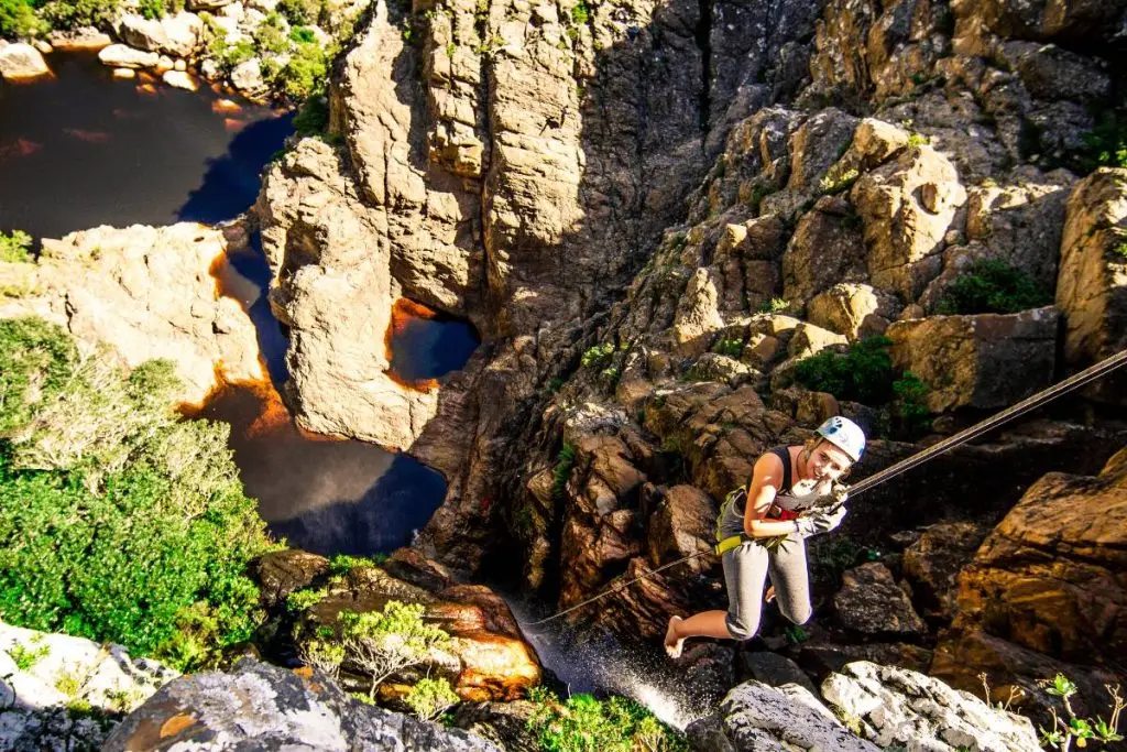Woman abseiling down a waterfall.