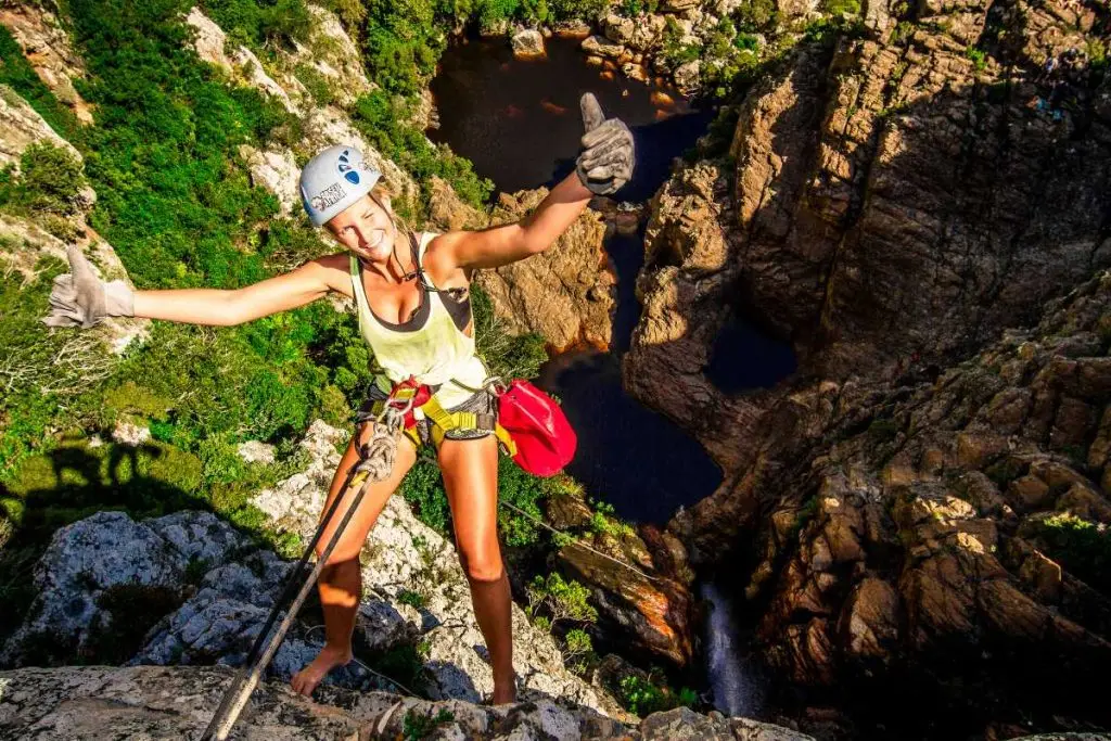 Woman abseiling down a waterfall.